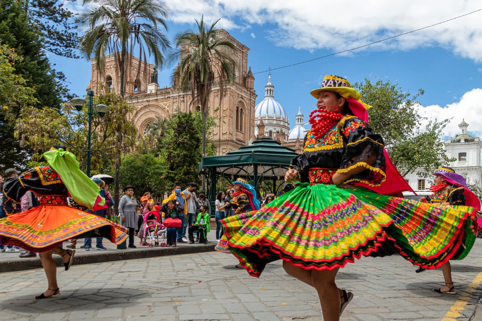 Tanzende Menschen in farbenfroher traditioneller Kleidung in Ecuador